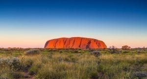 Uluru from a distance as the sunsets and the rock glows.